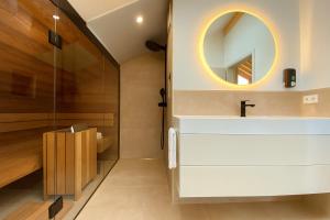 a bathroom with a sink and a mirror at Berg I Sauna I Balkon I See-Bergblick I Biohof in Rieden am Forggensee +18 photos