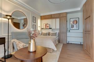 a bedroom with a bed and a table and a couch at Perspektywa Apartment with balcony by Lion Apartments in Gdańsk