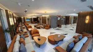 a lobby with a row of couches and tables at فندق نيوليفيل - New Level Hotel in Al Khansāk