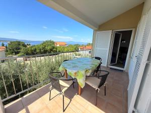 a patio with a table and chairs on a balcony at Großzügige 6-Personen Ferienwohnung in Kroatien in Malinska