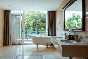 a bathroom with a tub and a large window at Golden Peach Riverside Manor in Guilin