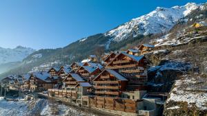 a group of buildings on a mountain in the snow at Madame Vacances La Cascade in Vaujany