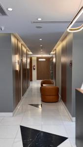 a hallway with a brown chair in a building at فندق نيوليفيل - New Level Hotel in Al Khansāk +41 photos