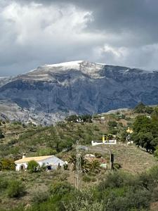 a snow covered mountain with a house on a hill at Ferienhaus Casa Piedra in Sedella