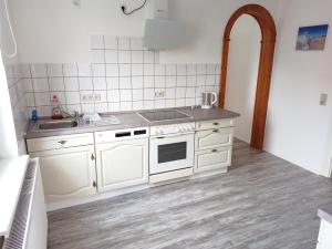 a white kitchen with a sink and a stove at Ferienwohnung Happy Life in Northeim