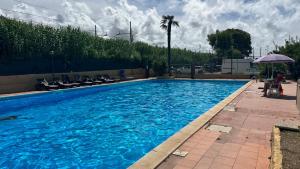 una gran piscina azul con sillas y sombrilla en Vera Italia, en Ladispoli