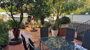 Un patio con mesas y sillas y árboles. en Vera Italia, en Ladispoli