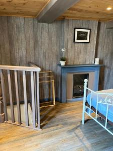 FumayにあるGîte Pierre et Meuseのベッドルーム1室(暖炉、ベッド1台付)、階段が備わります。