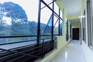 a room with large windows with a view of the forest at Igloo Residency in Vythiri