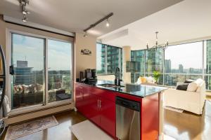 a kitchen with red cabinets and large windows at Summit Mountain & Skyline Views Beltline in Calgary