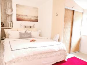 a bedroom with a large white bed with a pink rug at Freibeuter Appartement Nr 27 Scharbeutz in Scharbeutz