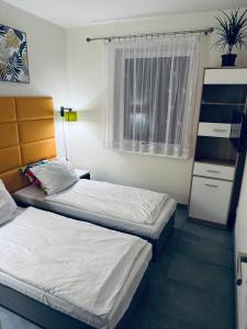 a room with two beds and a window at Apartament Nad Nielbą in Wągrowiec