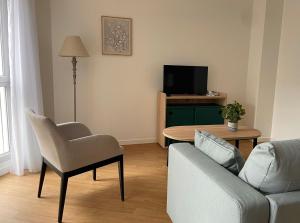 a living room with a couch and a table with a tv at Zenao Appart'hôtels Dijon in Dijon