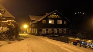 ペツ・ポト・スニェシュコウにあるApartmány Bouda 230の雪に覆われた通りの家