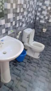 a bathroom with a white toilet and a sink at Blooming Mirissa in Mirissa