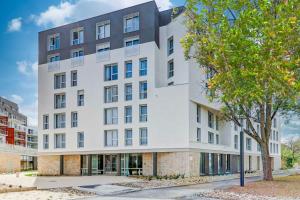 an exterior view of a white building at Zenao Appart'hôtels Dijon in Dijon