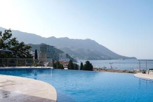 a large swimming pool with a view of the water at Skyline Sunset in Becici