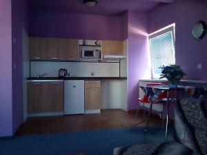 a kitchen with purple walls and a table in a room at Manhattan Penzion in Písek