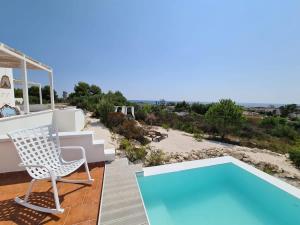 patio con sedia e piscina di Villa Alba Puglia - Experience Authentic Puglian Bliss a Marina di Lizzano