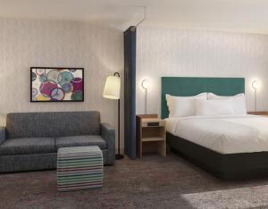 a hotel room with a bed and a couch at Home2 Suites By Hilton Hickory in Hickory