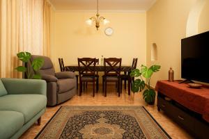 uma sala de estar com mesa, cadeiras e televisão em Garden of Sincerity em Maharagama