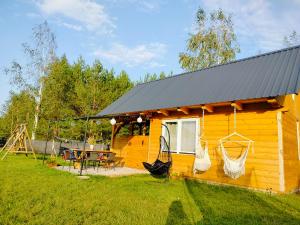 a small yellow cabin with a table and a swing at Chata z Pary in Prącki