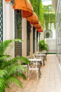 una fila de mesas y sillas con sombrillas en un patio en T-Ritz Saigon Hotel & Apartment, en Ho Chi Minh