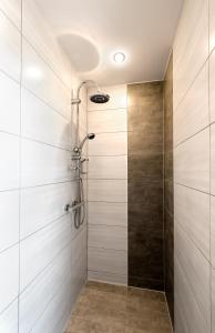 um chuveiro na casa de banho com azulejos brancos em Hotel Allegro em Halberstadt