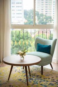 ホーチミン・シティにあるT-Ritz Saigon Hotel & Apartmentのリビングルーム(椅子、テーブル、窓付)