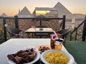 a table with two plates of food on a table with pyramids at Karnak temple pyramids view in Cairo +32 photos