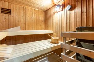 a wooden sauna with a clock on the wall at Strandhaus Claassen 06 in Ahrenshoop +22 photos