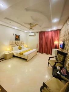 a large bedroom with a bed and a couch and a chair at Livin Hub Guest House in Islamabad +16 photos