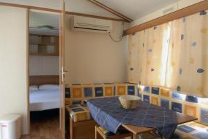 a small room with a table and a bunk bed at Camping La Rocca in Manerba del Garda +61 photos