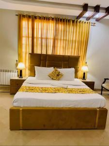 a bedroom with a large bed with a wooden headboard at Livin Hub Guest House in Islamabad