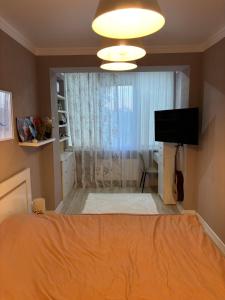 a bedroom with a bed and a flat screen tv at Small but cute flat in Durleşti