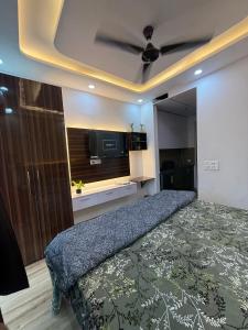a bedroom with a bed and a ceiling fan at Kaveri Stay in Greater Noida