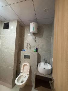 a small bathroom with a toilet and a sink at Kaveri Stay in Greater Noida