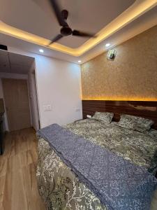 a bedroom with a bed and a ceiling fan at Kaveri Stay in Greater Noida +2 photos