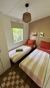 a bedroom with two beds and a window at Boutique Boshuisje op de Veluwe in Nunspeet