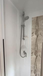 eine Badezimmertür mit Duschkopf darauf in der Unterkunft Boshuisje met kachel "Huisje van Loof" op de Veluwe in Nunspeet + 67 Fotos