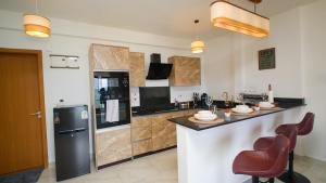 a large kitchen with a counter and a refrigerator at Best Stays Luxury Apartments at Sandy Shore - Kikambala in Kikambala