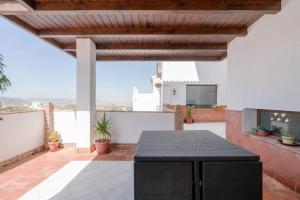 a patio with a black table on a roof at Spacious Villa in Granada with Private Pool and Jacuzzi in La Zubia