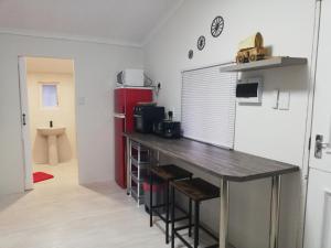 a kitchen with a table and a refrigerator in a room at Ossewa Rus in Sutherland