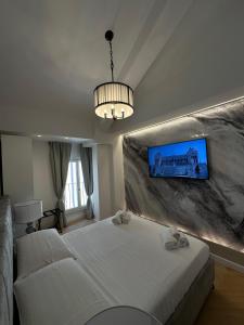 Un dormitorio con una cama y un televisor en la pared. en Charma Luxury Apartment - ROMA, en Roma