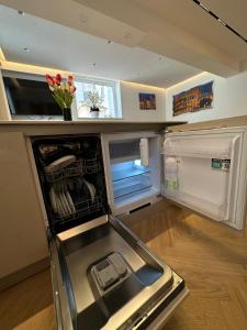an empty refrigerator with its door open in a kitchen at Charma Luxury Apartment - ROMA in Rome