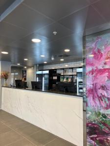 a lobby with a large painting on the wall at Cabinn Plus Esbjerg in Esbjerg
