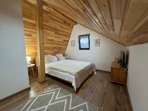 a bedroom with a bed and a wooden ceiling at Pensiunea Sufletul Pădurii in Valea Lupului