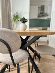 - une table en bois avec 2 chaises et un vase dans l'établissement Apartamento Plaza, à Castilleja de la Cuesta