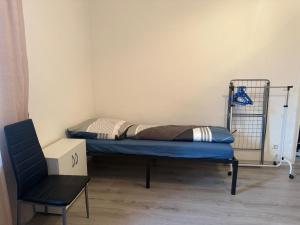 a small room with a bed and a chair at K&K Unterkunft Gelsenkirchen in Gelsenkirchen