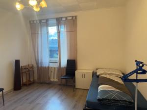 a bedroom with a bed and a window and a chair at K&K Unterkunft Gelsenkirchen in Gelsenkirchen